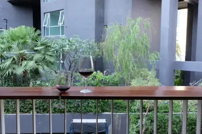 two glasses of wine sitting on a wooden table at Haus Sathorn 21 Bed and Breakfast in Bangkok