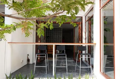 a couple of bar stools on the porch of a house at Haus Sathorn 21 Bed and Breakfast in Bangkok