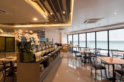 a restaurant with tables and chairs and a view of the ocean at Tarawish Hotel in Bangkok