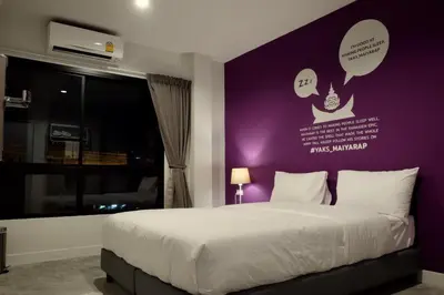 a bedroom with a large bed with a purple wall at Yaks House Hostel in Bangkok