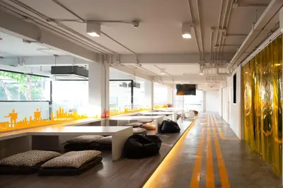 a room with couches and a table in a building at Yaks House Hostel in Bangkok