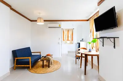 a living room with a blue chair and a table at Collection O Howard Square Boutique Hotel in Bangkok