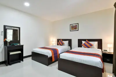two beds in a room with white walls at Studio Residence Sukhumvit 71 in Bangkok