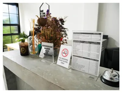 a counter with a sign and some plants on it at The Companion in Bangkok