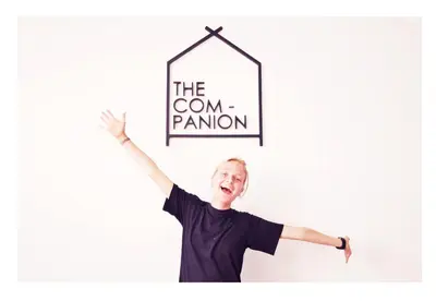 a man holding up a sign that reads the cornantom at The Companion in Bangkok