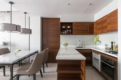 a kitchen with wooden cabinets and a table and chairs at Bangkok Marriott Hotel The Surawongse in Bangkok