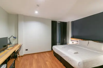 a bedroom with a large bed and a flat screen tv at Zleepmotion Bangkok in Bangkok