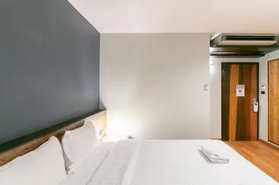 a bedroom with a large white bed with white pillows at Zleepmotion Bangkok in Bangkok