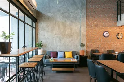 a room with a couch and tables and a brick wall at Zleepmotion Bangkok in Bangkok
