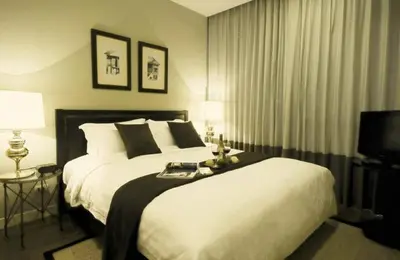 a bedroom with a large bed and a television at Rongratana Executive Residence Bangkok in Bangkok