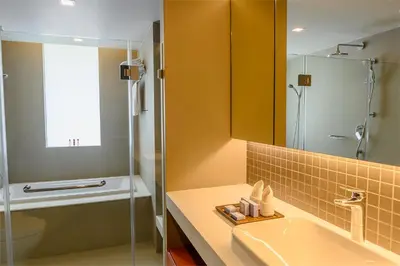 a bathroom with a sink and a shower and a mirror at Oakwood Residence Sukhumvit Thonglor Bangkok in Bangkok