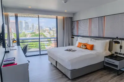 a bedroom with a large bed and a large window at Oakwood Residence Sukhumvit Thonglor Bangkok in Bangkok