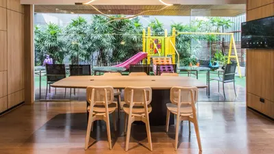 a table and chairs with a playground in the background at Oakwood Residence Sukhumvit Thonglor Bangkok in Bangkok