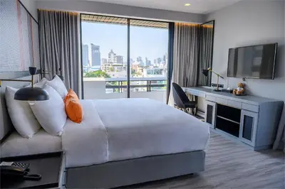 a hotel room with a large bed and a television at Oakwood Residence Sukhumvit Thonglor Bangkok in Bangkok