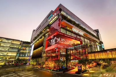 a tall red building with a sign on it at Golden Tulip Mandison Suites in Bangkok