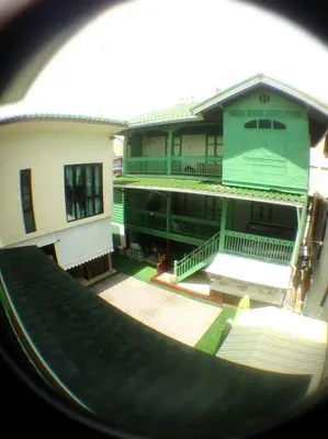 a view of a building from a porthole of a building at Green Teak House in Bangkok