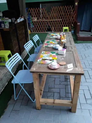a wooden table with chairs and plates on it at Green Teak House in Bangkok
