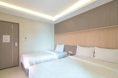 two beds in a hotel room with white sheets at Sleep Hotel Bangkok in Bangkok