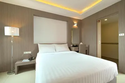 a bedroom with a large white bed and a lamp at Sleep Hotel Bangkok in Bangkok