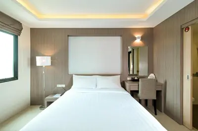 a bedroom with a large white bed and a desk at Sleep Hotel Bangkok in Bangkok