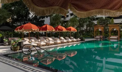 a swimming pool with chairs and umbrellas at Anantara Siam Bangkok Hotel in Bangkok