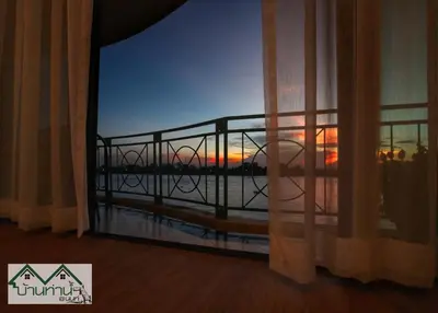 a room with a window with a view of the ocean at Baanthanam Nont in Nonthaburi