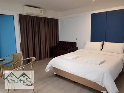 a hotel room with a bed and a chair at Baanthanam Nont in Nonthaburi