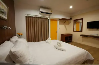 a bedroom with two towels on a white bed at Baanthanam Nont in Nonthaburi