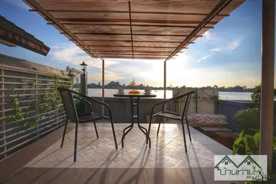 a patio with two chairs and a table on a balcony at Baanthanam Nont in Nonthaburi