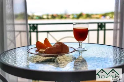 a glass table with a plate of food and a drink at Baanthanam Nont in Nonthaburi