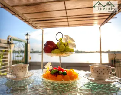 a display of fruit on a table with two cups at Baanthanam Nont in Nonthaburi