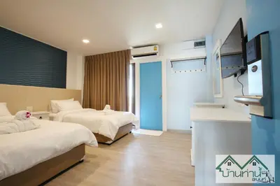 a hotel room with two beds and a television at Baanthanam Nont in Nonthaburi