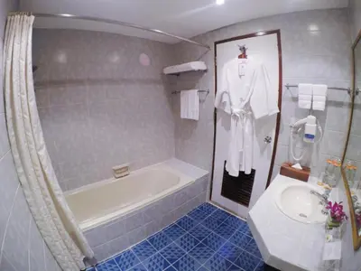 a bathroom with a bath tub and a sink at City Lodge Bangkok in Bangkok
