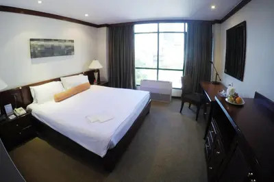 a hotel room with a large bed and a desk at City Lodge Bangkok in Bangkok