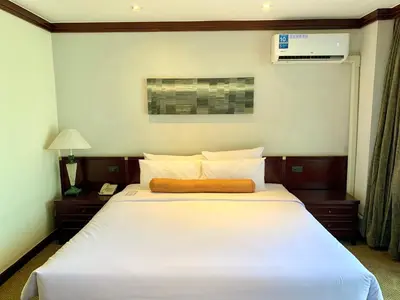 a bedroom with a large white bed and a lamp at City Lodge Bangkok in Bangkok