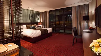 a hotel room with a bed and a desk and a bedroom at M2 de Bangkok Hotel in Bangkok