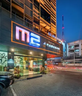 a building with a mfc sign on the side of it at M2 de Bangkok Hotel in Bangkok