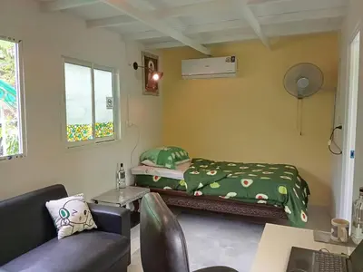 a small bedroom with a bed and a couch at Young and Beautiful in Bangkok