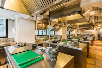 a large kitchen with lots of stainless steel appliances at Akara Hotel in Bangkok
