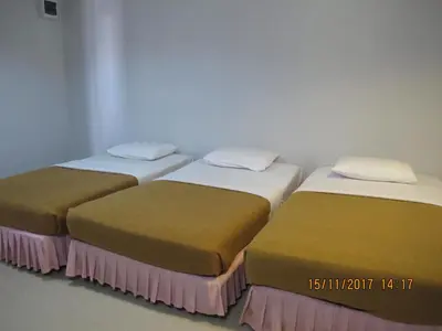 two beds are lined up in a room at Tongpoon Hotel in Bangkok