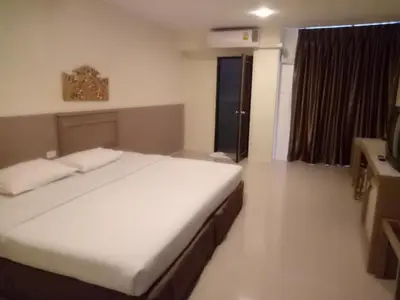a bedroom with a bed and a television in it at Tongpoon Hotel in Bangkok