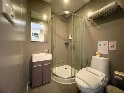 a bathroom with a shower and a toilet and a sink at Arawana Express Phromphong in Bangkok