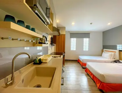a bathroom with two beds and a sink in a room at Arawana Express Phromphong in Bangkok