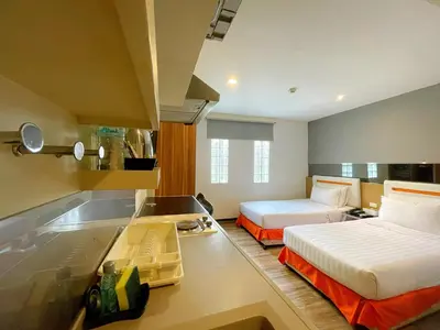 a large room with two beds and a kitchen at Arawana Express Phromphong in Bangkok
