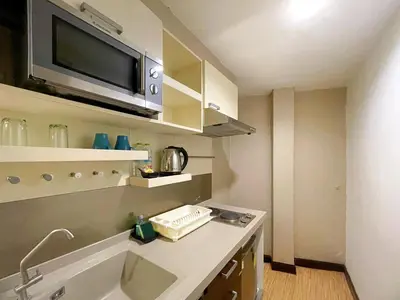 a small kitchen with a sink and a microwave at Arawana Express Phromphong in Bangkok