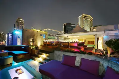 a rooftop bar with purple furniture and a city skyline at Galleria 10 Hotel Bangkok in Bangkok