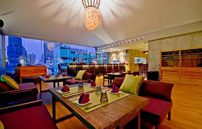 a restaurant with tables and chairs and a large window at Galleria 10 Hotel Bangkok in Bangkok