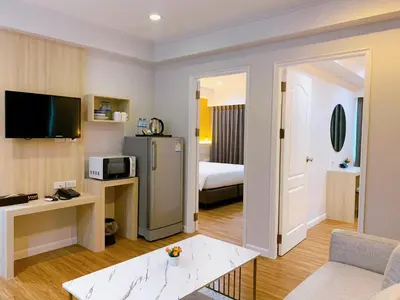 a hotel room with a living room with a bed at Miloft Sathorn Hotel in Bangkok