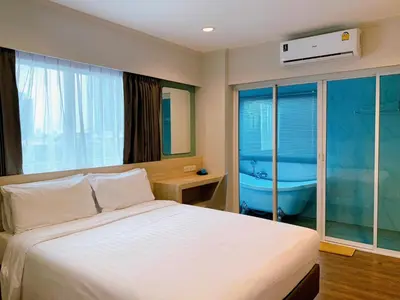 a bedroom with a bed and a bath tub in it at Miloft Sathorn Hotel in Bangkok