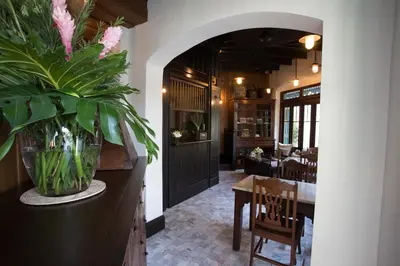 a dining room with a table and a vase of flowers at 1905 Heritage Corner in Bangkok